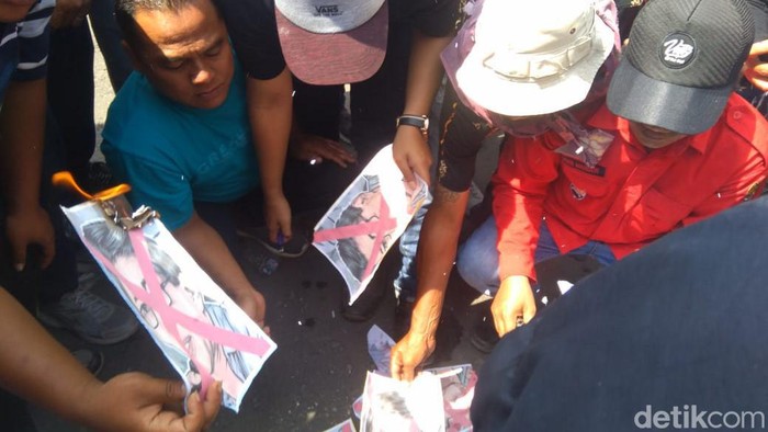 Massa berunjuk rasa menolak Rocky Gerung di Mojokerto. Mereka sempat membakar gambar akademisi tersebut.