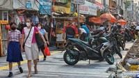 Sejumlah pejalan kaki melintas pada proyek revitalisasi dan pelebaran trotoar di Jl Pancoran, Glodok, Jakarta, Jumat (11/8/2023).  