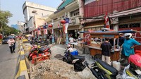 Tampak deretan kendaraan roda dua terparkir di jalur pedestrian yang sedang dalam proses pelebaran tersebut.  