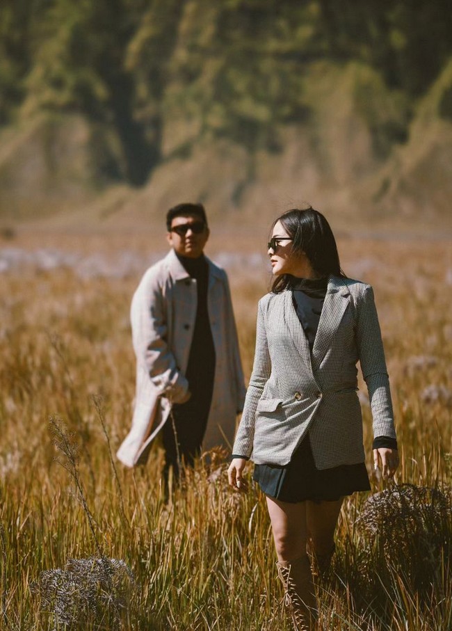 Pada sesi foto lainnya, pasangan musisi dan model ini tampil dengan gaya preppy. Keduanya kompak memakai blazer dan coat sebagai luaran di atas busana hitam. Foto: Instagram/@faralljibrill @denny_caknan