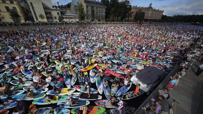 People steer their stand-up paddle (SUP) boards along the Griboedov Channel during the annual costumed 'Fontanka' SUP-boards festival in St. Petersburg, Russia, Saturday, Aug. 5, 2023. (AP Photo/Dmitri Lovetsky)