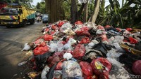 Kendaraan melintas di samping sampah yang menumpuk di pinggir Jalan Serpong-Parung, Jumat (11/8/2023).  