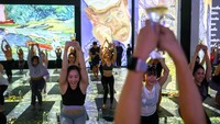 Komunitas Brew Yoga Thailand berkolaborasi dengan penyelenggara Van Gogh Alive mengajak pengunjung menikmati sensasi yoga dan hasil karya Vincent Van Gogh di BKK Exhibition, ICON Siam, pada Sabtu (5/8/2023).  