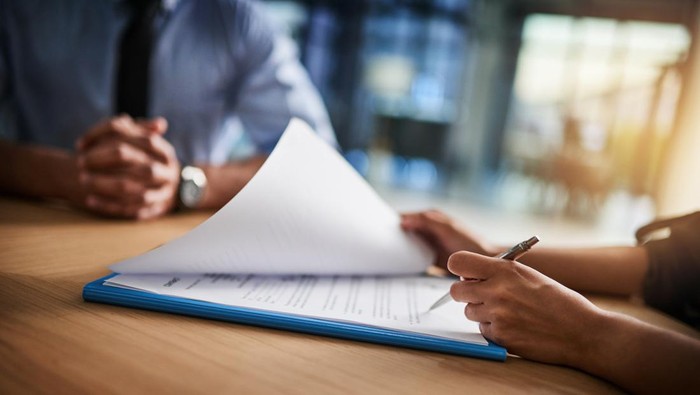 Cropped shot of a man and woman completing paperwork together at a desk