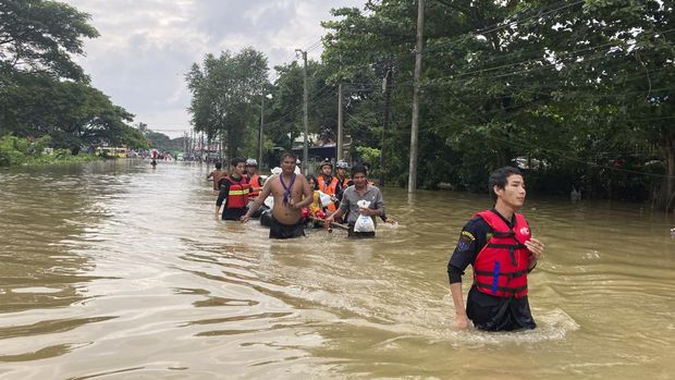 Anggota tim penyelamat membawa penduduk dengan perahu di sepanjang jalan nan terendam banjir di Bago, Myanmar, sekitar 80 kilometer (50 mil) timur laut Yangon, Jumat, 11 Agustus 2023. (AP Photo)