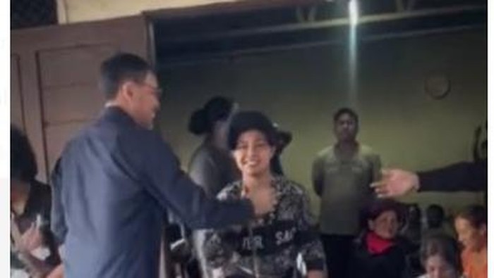 JR Saragih saat menyalami warga yang dibagikannya  uang. (Foto: Istimewa)