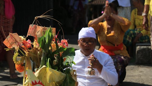 Ritual upacara di depan pintu masuk utama rumah warga Banjar Adat Bongan Gede, Desa Bongan, Kecamatan Tabanan, Kabupaten Tabanan, Bali, yang mengawali tradisi Mesuryak saat Kuningan, Sabtu (12/8/2023).