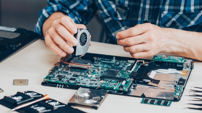 Computer repair service. Hardware support. Electronic technology. Cropped shot of technician fixing laptop cooler.