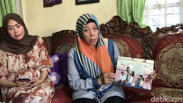 Ibu Bunga (pegang foto) memperlihatkan foto saat Bunga masih kecil bersama sang ayah.
