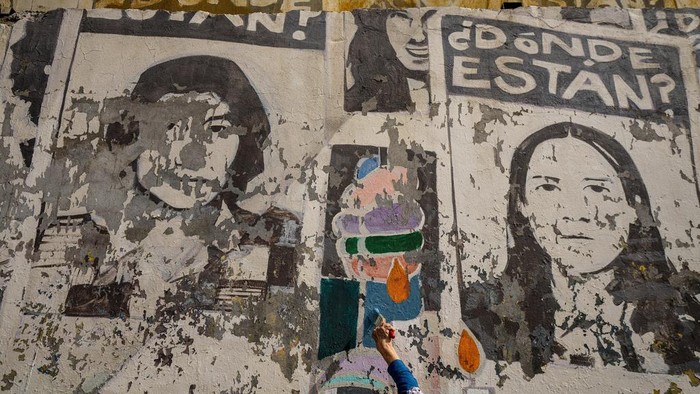 Mantan tahanan politik di Santiago melakukan restorasi mural mattan presiden Salvador di Santiago. Begini potretnya.