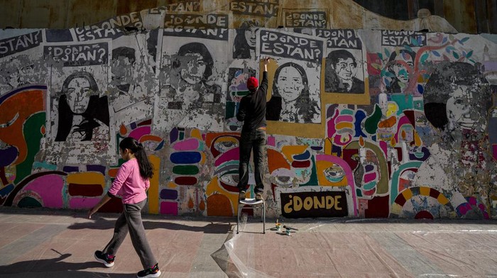 Mantan tahanan politik di Santiago melakukan restorasi mural mattan presiden Salvador di Santiago. Begini potretnya.