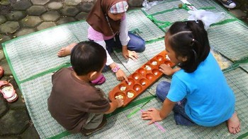 Congklak, biasanya digemari oleh anak-anak perempuan. Permainan ini menggunakan biji-biji kerang yang dipindah dari satu lubang ke lubang lainnya. Foto: Twitter