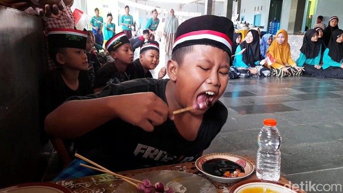 Para santri di Pondok Pesantren Baitul Quran, Kelurahan Brekat, Kecamatan Tarub, Kabupaten Tegal, mengikuti lomba makan sate bawang mentah. Begini ekspresi dan keseruannya, Minggu (13/8/2023).