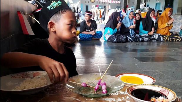 Para santri di Pondok Pesantren Baitul Quran, Kelurahan Brekat, Kecamatan Tarub, Kabupaten Tegal, mengikuti lomba makan sate bawang mentah. Begini ekspresi dan keseruannya, Minggu (13/8/2023).