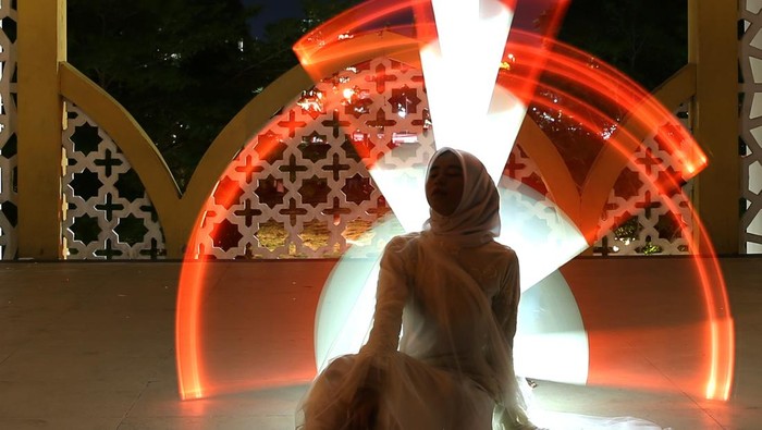 Potret Kreasi Lukisan Cahaya HUT RI Karya Komunitas Fotografi di Banda Aceh Model berpose pada kegiatan kreasi lukisan cahaya (light painting) nuansa merah putih yang diselenggarakan komunitas fotografi Instanusantara Aceh di Taman Bustanussalatin, Banda Aceh, Aceh, Sabtu (12/8/2023). Light painting yang dilakukan dengan menggunakan kecepatan rana (shutter speed) lambat sehingga dapat merekam garis cahaya yang dibuat dengan berbagai bentuk tersebut dilaksanakan dalam rangka memeriahkan HUT ke-78 Kemerdekaan Republik Indonesia. ANTARA FOTO/Irwansyah Putra/YU