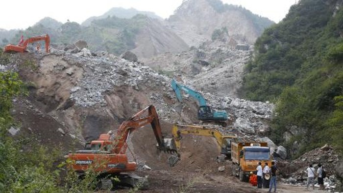 Rescuers look for victims of a deadly landslide in Shanyang, north Chinas Shaanxi province on August 13, 2015. More than 60 people were missing in China on August 12 after a landslide buried the living quarters of a mining company under one million cubic metres of earth, state media said.  CHINA OUT   AFP PHOTO (Photo by AFP)