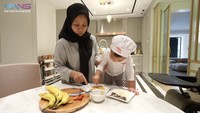 Rayyanza ternyata handal loh memberikan topping ke atas pisang demplon buatannya. Dengan jemarinya ia mengambil sejumput meses dan keju.