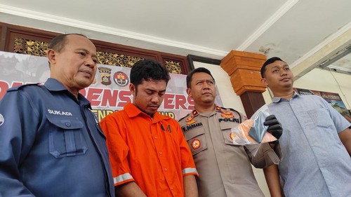 I Nengah Juliana, driver ojol pemungut HP terjatuh di jalan menjadi tersangka dihadirkan saat konferensi pers di Polsek Denpasar Timur.