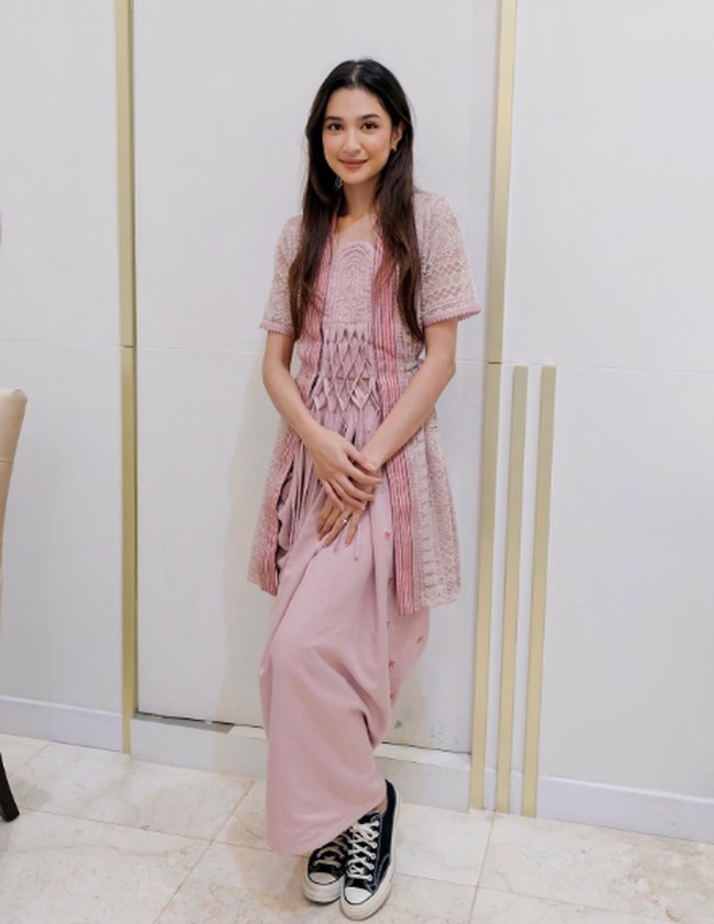 Penampilan anggunnya kali ini dilengkapi dengan sneakers yang santai. Terdapat sentuhan jarik yang tradisional pada gaun lace-nya. Foto: Instagram @miktambayong