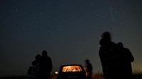 People watch as meteor streaks in the night sky during the annual Perseid meteor shower in the Siberian town of Yeniseysk in the Krasnoyarsk Region, Russia August 12, 2023. REUTERS/Alexey Malgavko