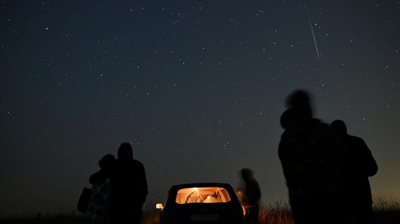 People watch as meteor streaks in the night sky during the annual Perseid meteor shower in the Siberian town of Yeniseysk in the Krasnoyarsk Region, Russia August 12, 2023. REUTERS/Alexey Malgavko