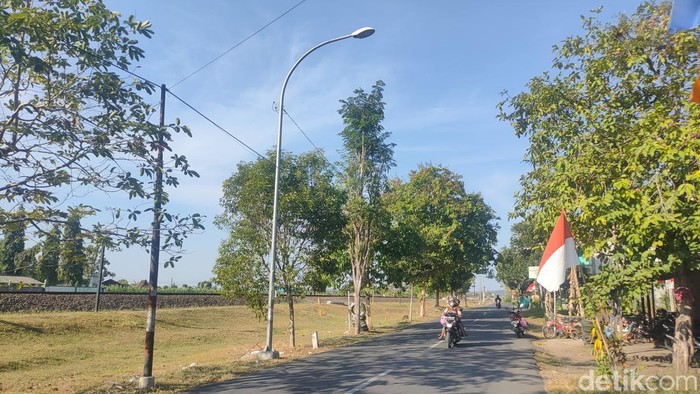 Pengendara melintas di jalur yang telah terpasang LPJU di Wates, Kulon Progo, Senin (14/8/2023).
