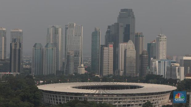 Sejumlah karyawan melihat gedung bertingkat yang tertutup oleh kabut polusi di Jakarta, Senin, (14/8). (CNBC Indonesia/Muhammad Sabki)