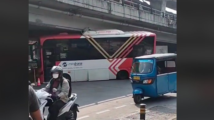 Video bus Minitrans tersangkut di kolong flyover Velbak Kebayoran Lama viral di medsos. Bus tersebut juga mengalami kerusakan akibat insiden tersebut. (Tangkapan layar video viral)