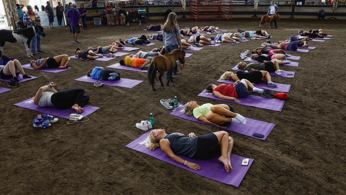Warga AS Ikut Kelas Yoga di Kandang Kuda Fairgoers take a yoga class with miniature horses at the Livestock Pavilion at the Iowa State Fair in Des Moines, Iowa, U.S. August 13, 2023. REUTERS/Evelyn Hockstein