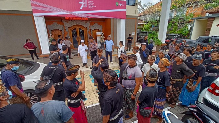 Warga Desa Tegal Mengkeb berdiam di pelataran depan PN Tabanan saat pembacaan gugatan sengketa lahan Pura Dalem Kelecung, Senin (14/8/2023). (chairul amri simabur/detikBali)