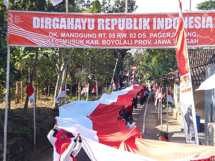 Warga Dukuh Manggung, Desa Pager Jurang, Kecamatan Musuk, Kabupaten Boyolali mengarak dan membentangkan 4 bendera merah putih sepanjang total 148 meter, Senin (14/8/2023) sore.