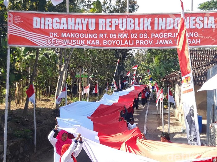 Warga Dukuh Manggung, Desa Pager Jurang, Kecamatan Musuk, Kabupaten Boyolali mengarak dan membentangkan 4 bendera merah putih sepanjang total 148 meter, Senin (14/8/2023) sore.