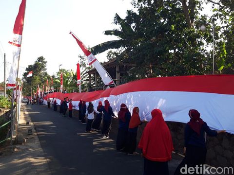 Warga Dukuh Manggung, Desa Pager Jurang, Kecamatan Musuk, Kabupaten Boyolali mengarak dan membentangkan 4 bendera merah putih sepanjang total 148 meter, Senin (14/8/2023) sore.