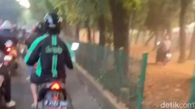 Aksi sejumlah pemotor ini tidak pantas ditiru. Mereka melaju di taman tepi Jalan Lenteng Agung, Jakarta Selatan (Jaksel), untuk menghindari macet. (dok Pribadi/Dian M)