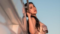 Amelia NS bergaya di kapal dengan pemandangan laut dan sunset. (Foto: dok Instagram)