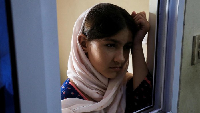 Asa Warga Afghanistan Menanti Visa AS yang Mandek Asra, 14, stands at a window of a rented house, while staying with her family and waiting for their special visa created by Western governments to protect the Afghans, in Rawalpindi, Pakistan August 7, 2023. REUTERS/Fayaz Aziz REFILE - CORRECTING NAME FROM 'ISRA' TO 'ASRA'