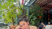 Ia sering membagikan pose cantiknya ketika makan di sebuah restoran. Posenya ini terlihat sedang menunggu pesanan makanannya. Foto: Instagram @azizahsalsha_