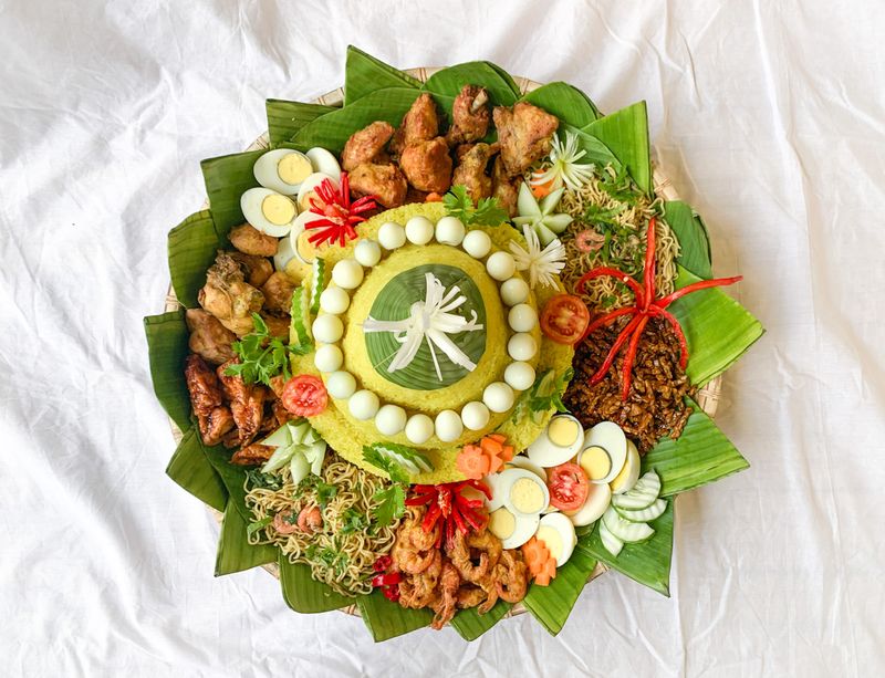 Traditional dish named Nasi Tumpeng, yellow rice cone shape with various side dish around. Usually served to celebrate birthdays or anniversary and formal events in Indonesia.