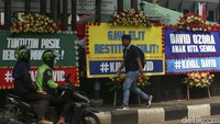 Pejalan kaki melintas di depan karangan bunga di Pengadilan Negeri Jakarta Selatan, Selasa (15/8/2023). 