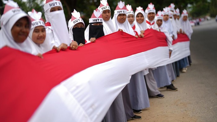 Sejumlah siswa membentangkan bendera merah putih di jalan protokol di Kendari, Sulawesi Tenggara, Selasa (15/8/2023). Menjelang Hari Kemerdekaan ke-78 RI pada 17 Agustus 2023 pemerintah setempat bersama 17 ribu siswa SMA dan SMK di Kendari membentangkan bendera merah putih sepanjang 17 kilometer di jalan poros penghubung antara Teluk Kendari hingga perbatasan Kabupaten Konawe Selatan. ANTARA FOTO/Jojon/foc.