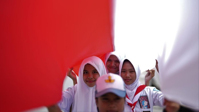 Sejumlah siswa membentangkan bendera merah putih di jalan protokol di Kendari, Sulawesi Tenggara, Selasa (15/8/2023). Menjelang Hari Kemerdekaan ke-78 RI pada 17 Agustus 2023 pemerintah setempat bersama 17 ribu siswa SMA dan SMK di Kendari membentangkan bendera merah putih sepanjang 17 kilometer di jalan poros penghubung antara Teluk Kendari hingga perbatasan Kabupaten Konawe Selatan. ANTARA FOTO/Jojon/foc.