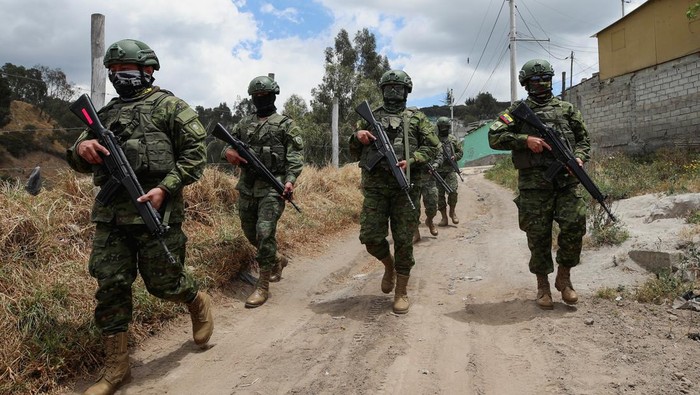 Pengamanan Ketat Pemilu Ekuador Buntut Pembunuhan Calon Presiden A soldier checks a driver at a military checkpoint prior to Sunday's presidential election, in Quito, Ecuador, August 14, 2023. REUTERS/Henry Romero