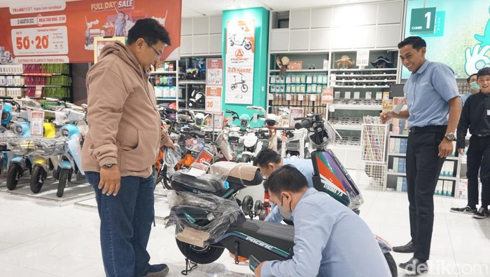 Seorang pelanggan Transmart di Surabaya menunjukkan kartu kredit Bank Mega Syariah usai belanja sepeda listrk di Transmart.