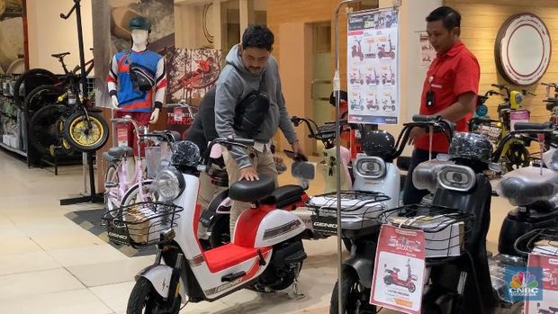 Seorang pengunjung melihat sepeda listrik di Transmart Cempaka Putih Jakarta pada Selasa (15/8/2023) selama promo Transmart Full Day Sale. (CNBC Indonesia/ Eqqi Syahputra)
