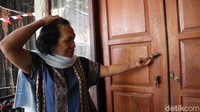 Pemilik rumah saat menunjukkan gagang pintu yang rusak gegara didobrak polisi. (Foto: Bima Bagaskara/detikJabar).