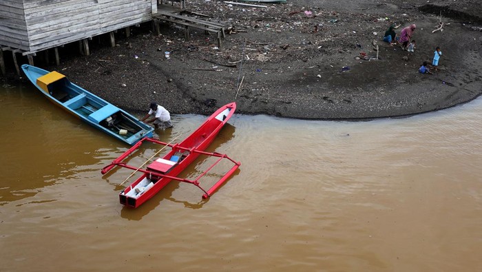 Sungai Sagea di Halmahera Tengah tercemar Nelayan membersihkan perahunya di Sungai Sagea, Desa Sagea, Kabupaten Halmahera Tengah, Maluku Utara, Selasa (15/8/2023). Sungai Sagea dengan panjang 7.476 kilometer dan menjadi jalur menuju objek wisata Goa Boki Maruru itu kondisi airnya berubah warna menjadi keruh akibat tercemar sedimentasi yang diduga berasal dari aktivitas pertambangan, sehingga menyebabkan warga tidak bisa lagi memanfaatkan air sungai untuk kebutuhan sehari-hari .ANTARA FOTO/Adlun fikri/ans/rwa.