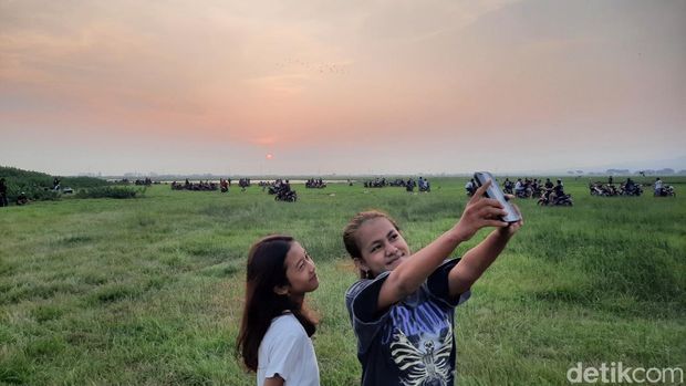 Warga berburu sunset di rawa yang mengering di Jakenan, Pati, Selasa (15/8/2023).