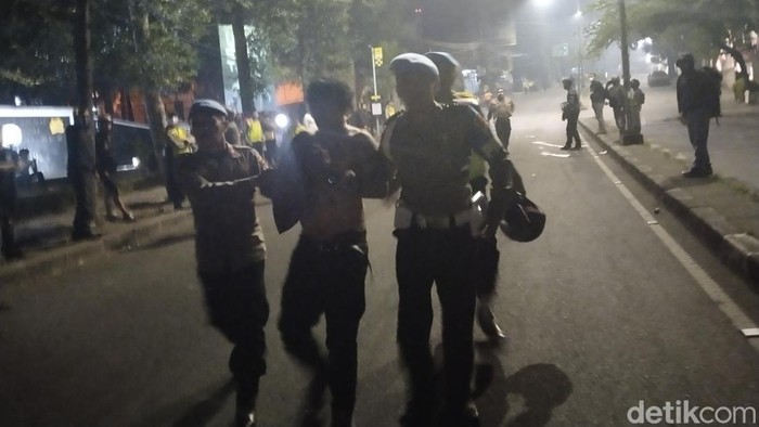 Warga diamankan polisi di sela aksi di Jalan Dago, Kota Bandung, Senin (14/8/2023) malam.
