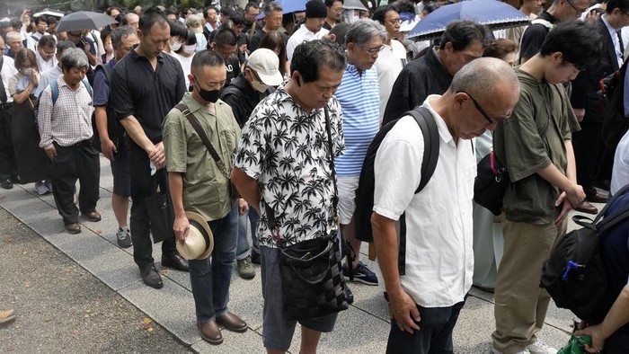 Visitors observe a minute of silence at noon at the Yasukuni Shrine, which honors Japans war dead, Tuesday, Aug. 15, 2023, in Tokyo, Japan. Japan holds annual memorial service for the war dead as the country marks the 78th anniversary of its defeat in the World War II. (AP Photo/Eugene Hoshiko)