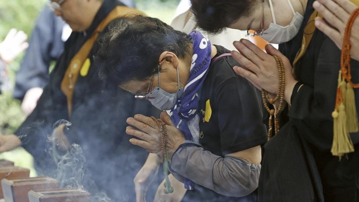 Warga Jepang Mengheningkan Cipta Saat Peringatan Perang Dunia II People offer prayers to the war dead, at the Chidorigafuchi National Cemetery, where the remains of unknown victims of World War II are honored, in Tokyo, Japan, Tuesday, Aug. 15, 2023. Japan holds annual memorial service for the war dead as the country marks the 78th anniversary of its defeat in the World War II. (Kyodo News via AP)